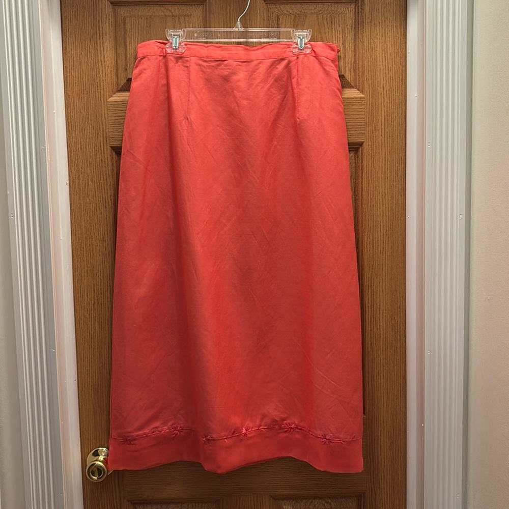 Long modest Caran New York coral skirt with design at bottom.